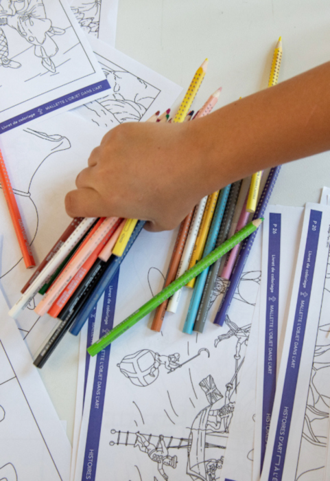 Des mains avec des crayons de couleur