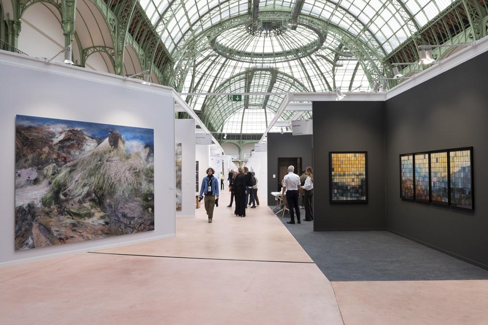 des personnes au milieu des stands de Paris Photo dans la Nef du Grand Palais
