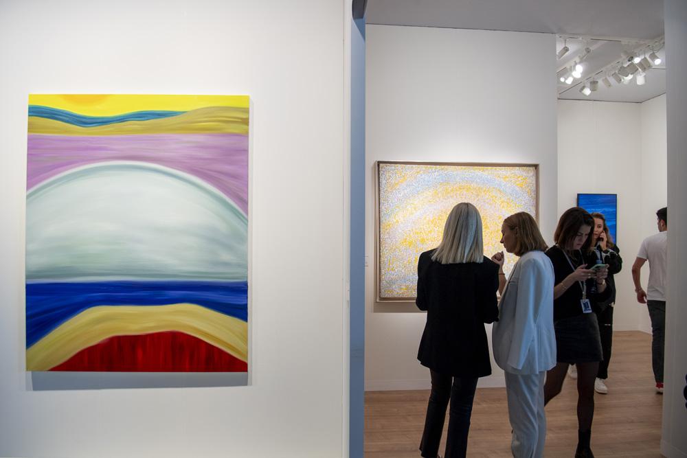 Des personnes discutent devant des tableaux