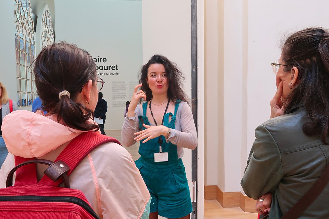 Une conférencière LSF en visite avec du public, au Grand Palais
