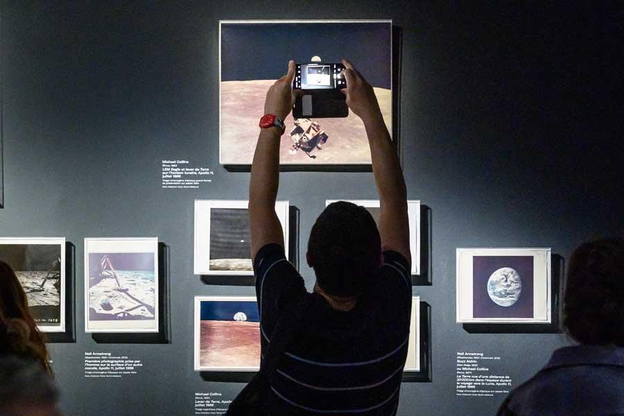 Image de visiteur prenant une photo dans une exposition